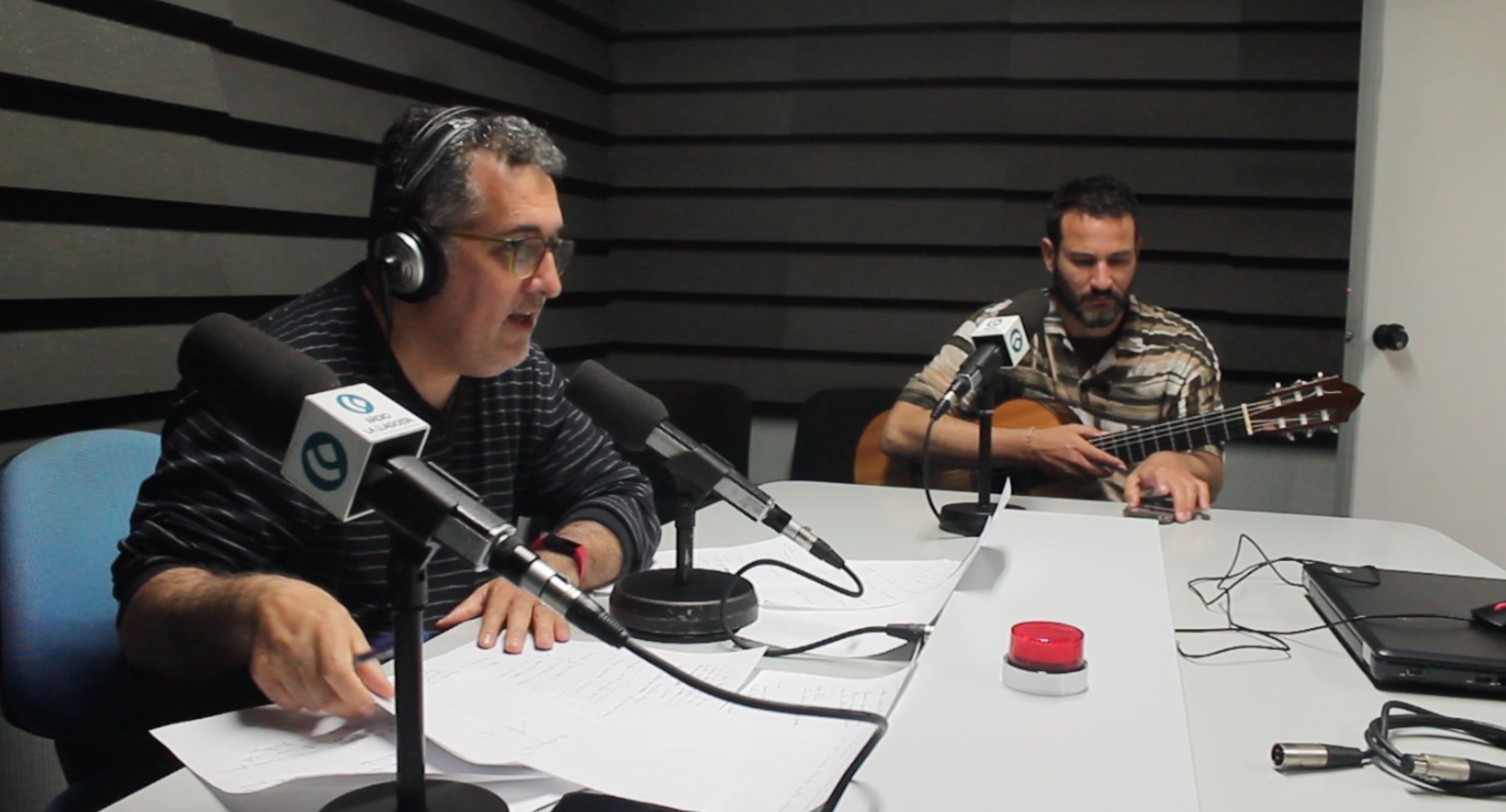 Hugo Arán, con la guitarra, en el momento de ser entrevistado por Jesús Abad en el programa Glocal de Ràdio la Llagosta